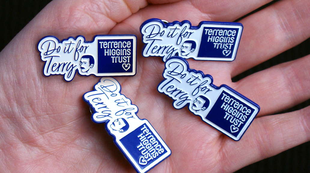 Do it for Terry blue and white pin badges on a hand.