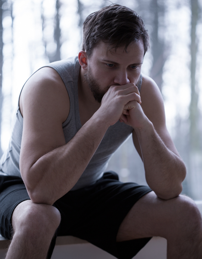 A man sits down, looking sad.