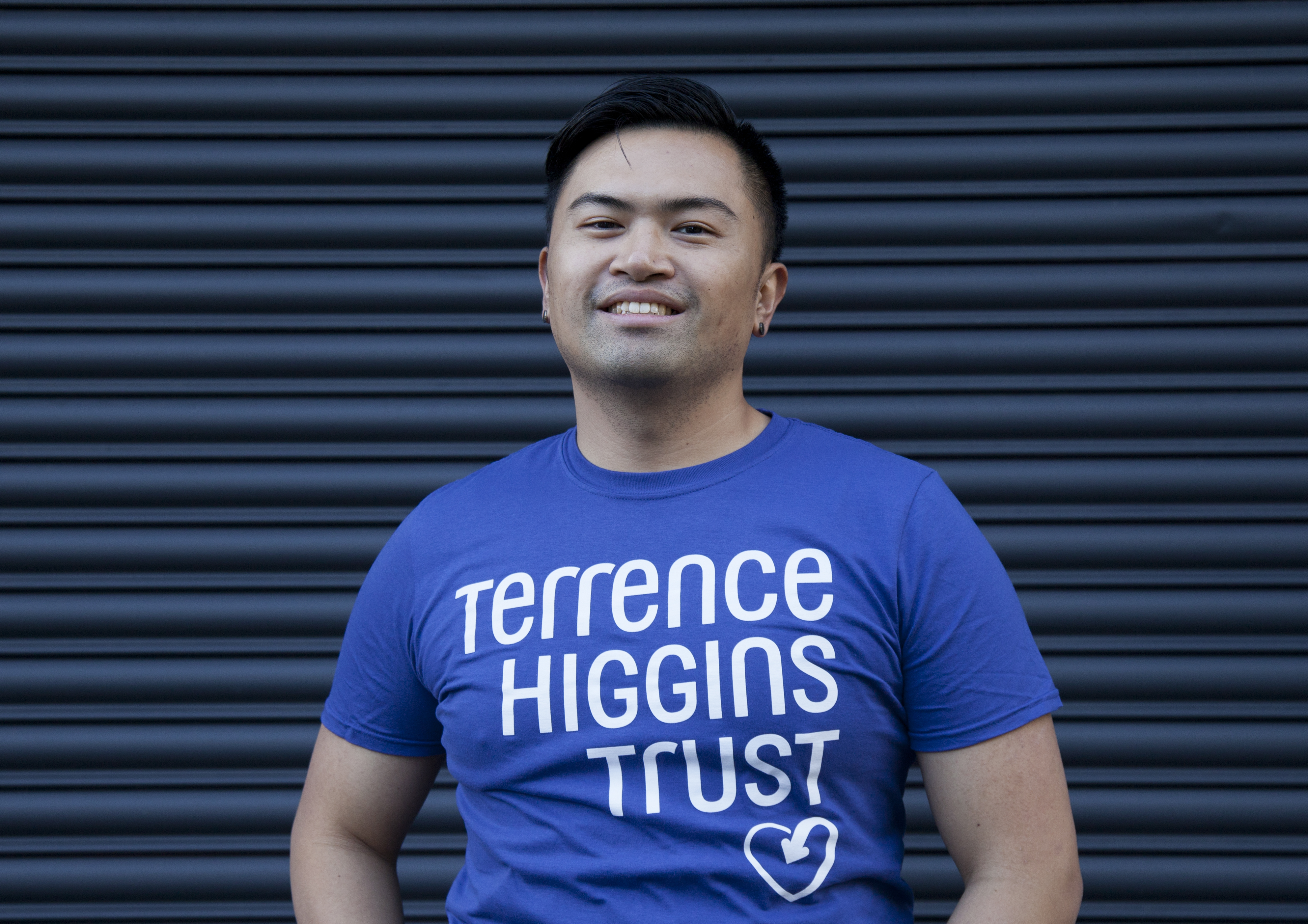 A smiling man wearing a Terrence Higgins Trust t-shirt.