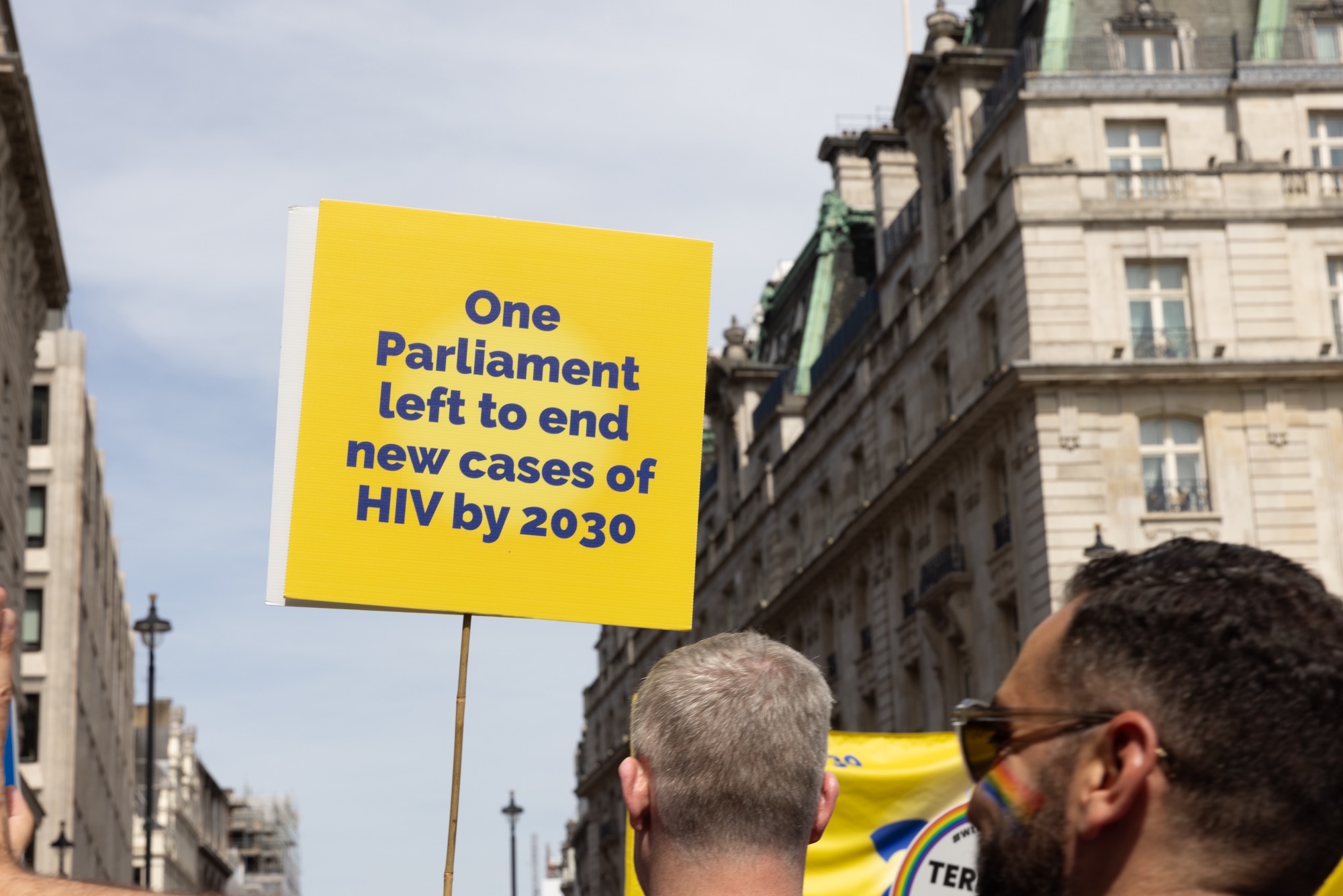 A placard held up reading "One Parliament left to end cases of HIV by 2023".