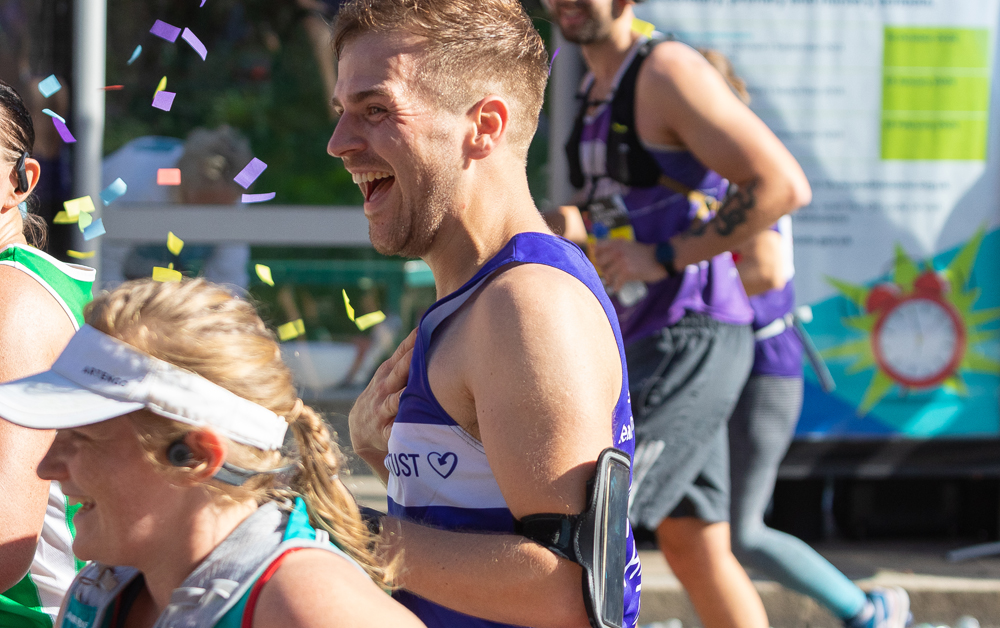 Marathon runner smiling in Terrence Higgins Trust vest