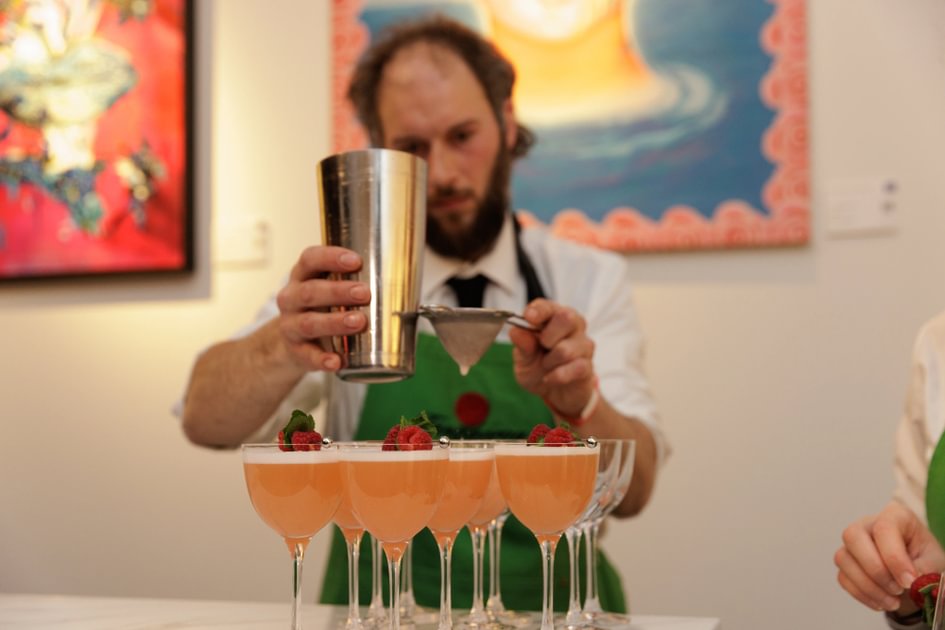 A mixologist at the 2026 Terrence Higgins Trust Auction prepares a set of drinks.
