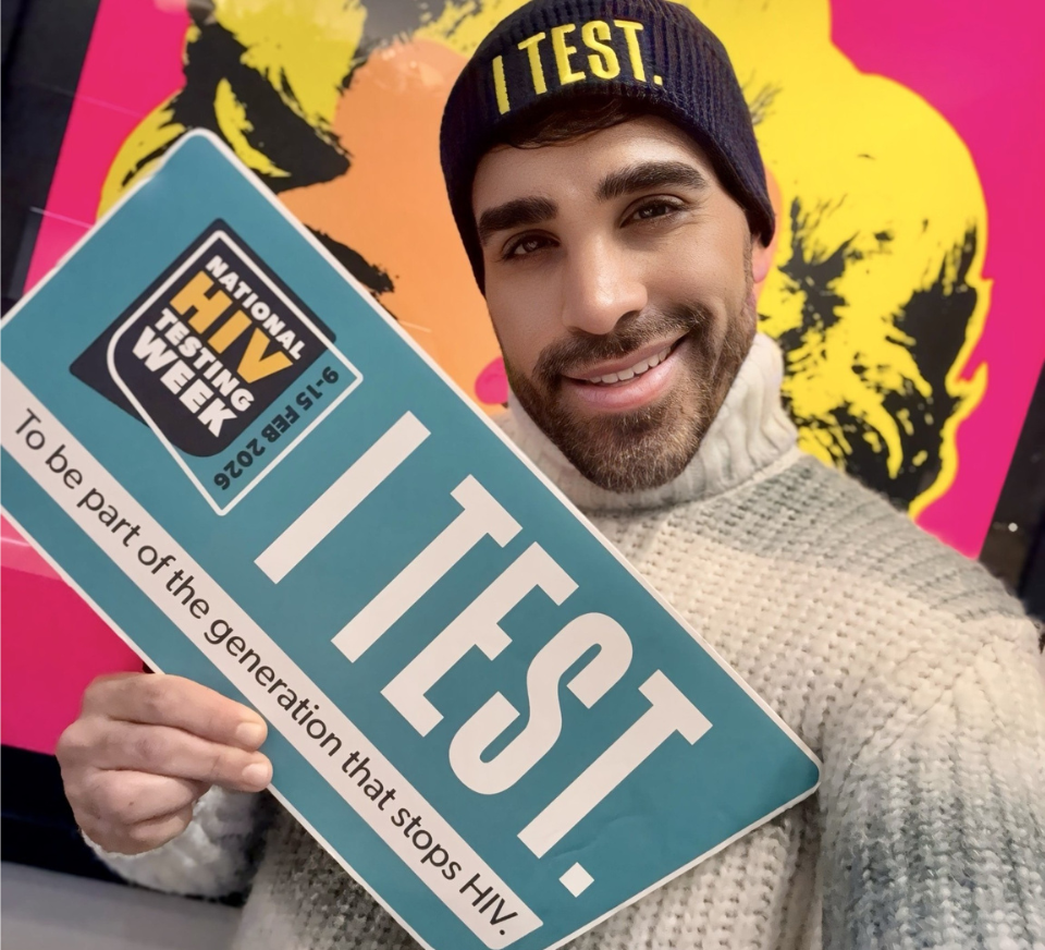 Dr Ranj holds an 'I Test' sign for National HIV Testing Week.