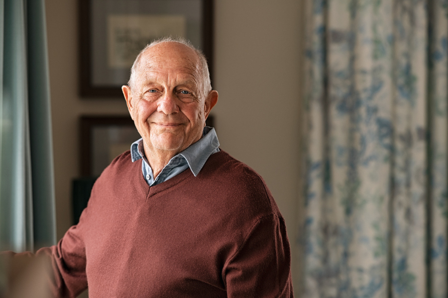An older man faces the camera smiling