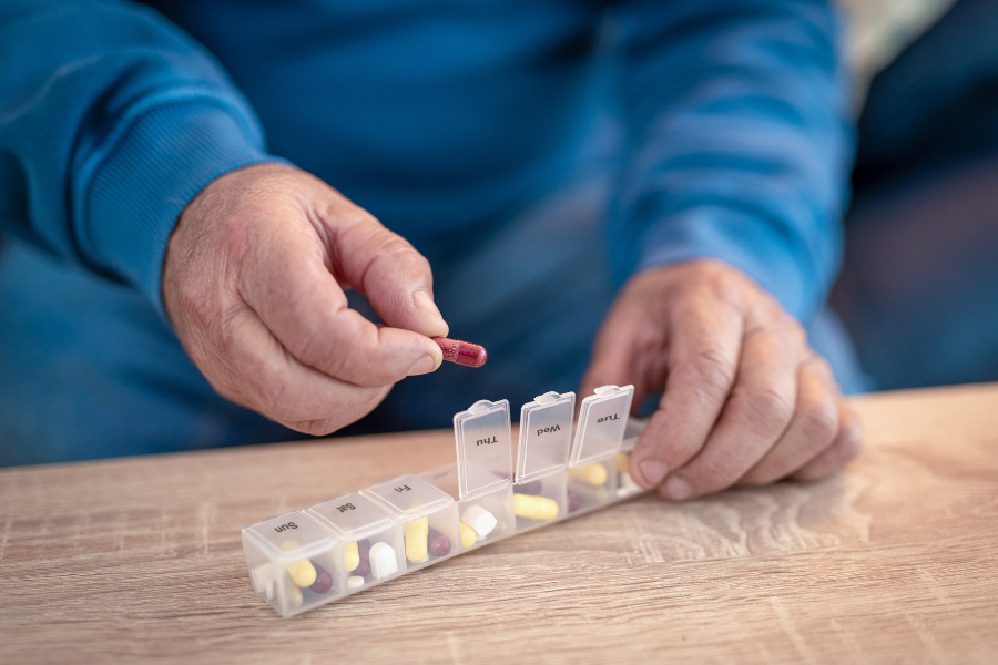 A older person uses a pill box