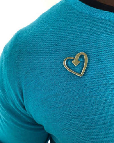 Gold heart badge on a teal jumper