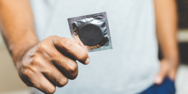 Condom A person holding a condom.