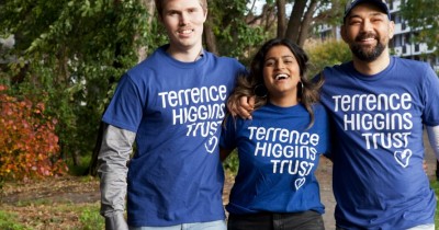 Two men and a woman smiling in Terrence Higgins Trust T-shirts.