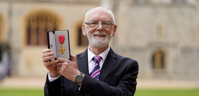 Martyn Butler holding his OBE.