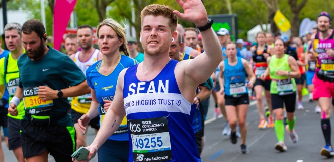 A waving Terrence Higgins Trust runner at the London Marathon.