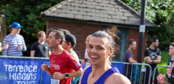 A smiling marathon runner in a Terrence Higgins Trust vest.