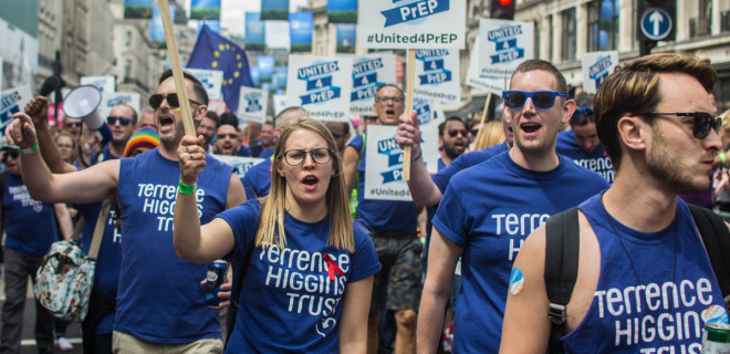 Terrence Higgins Trust staff and volunteers with banners and signs marching during Pride