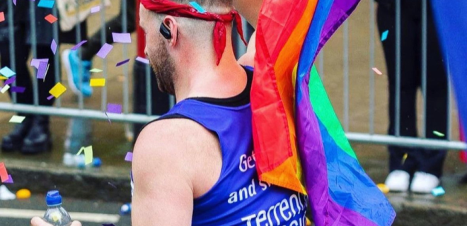 A Terrence Higgins Trust runner with a Pride flag.