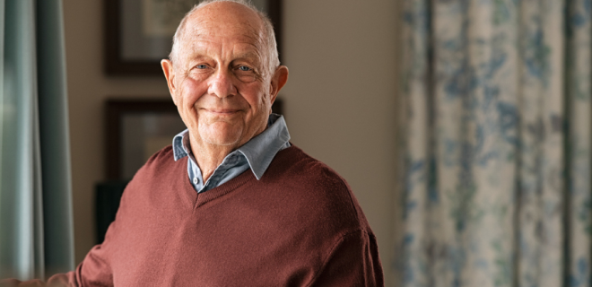 An older man faces the camera smiling