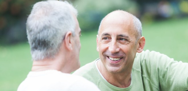 two older men chat to each other outside