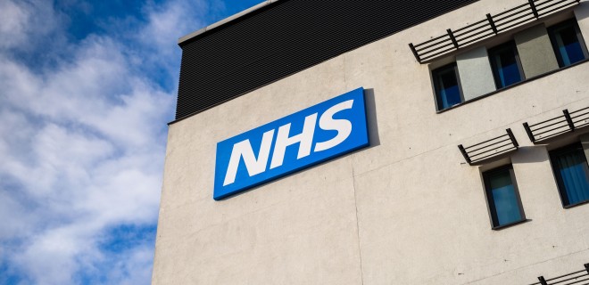 Blue and white NHS sign on a building.