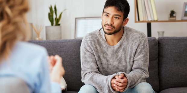 A man sitting in a counselling session.