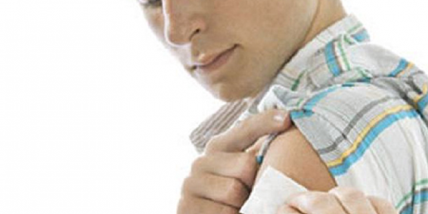 Man holding patch on arm after vaccination