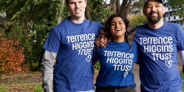 Two men and a woman smiling in Terrence Higgins Trust T-shirts.