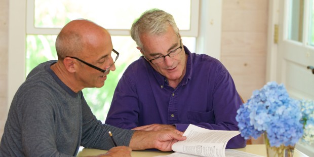 An older gay couple going through papers and writing.