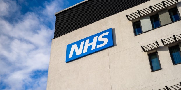 Blue and white NHS sign on a building.