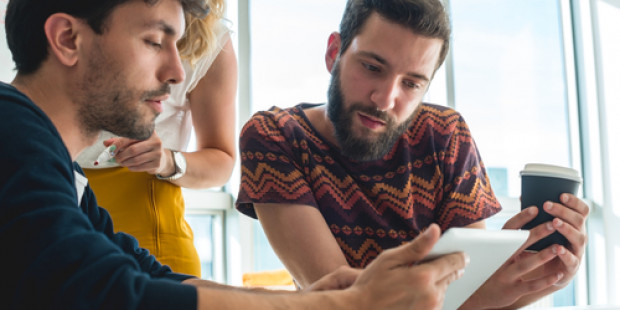 Three young people browsing tablet Three young people browsing tablet