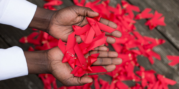 World AIDS day red ribbons in hands