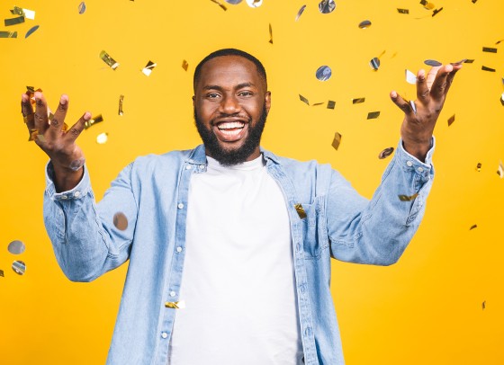 A man in a celebratory pose, smiling.